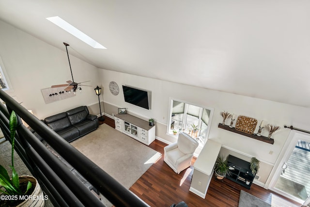 living area with ceiling fan, dark wood-style flooring, lofted ceiling with skylight, and baseboards