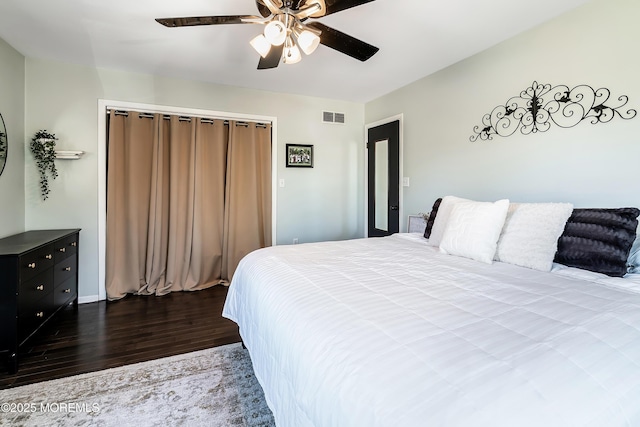 bedroom featuring dark wood finished floors, visible vents, and a ceiling fan