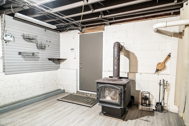 unfinished below grade area featuring concrete block wall and wood finished floors