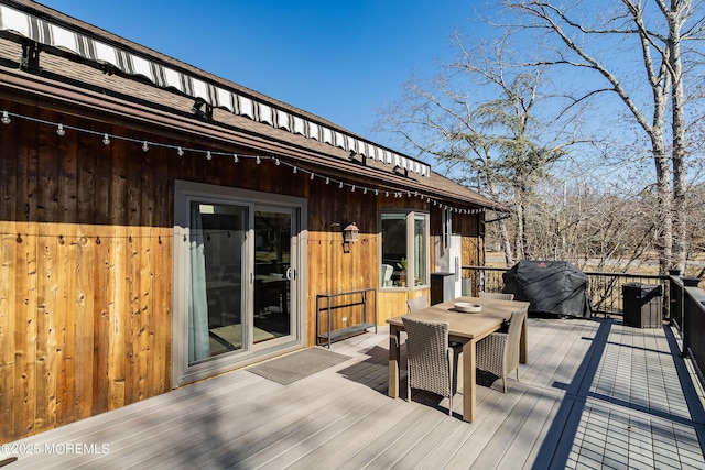 deck featuring outdoor dining space and grilling area