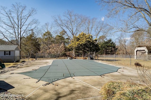 view of swimming pool featuring fence, an outdoor structure, and a patio