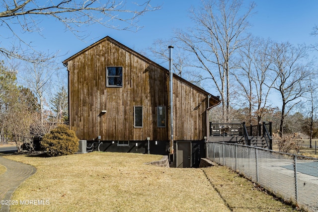 view of home's exterior with a yard, fence, and a wooden deck