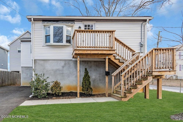 view of front of home with stairs, a front yard, and fence