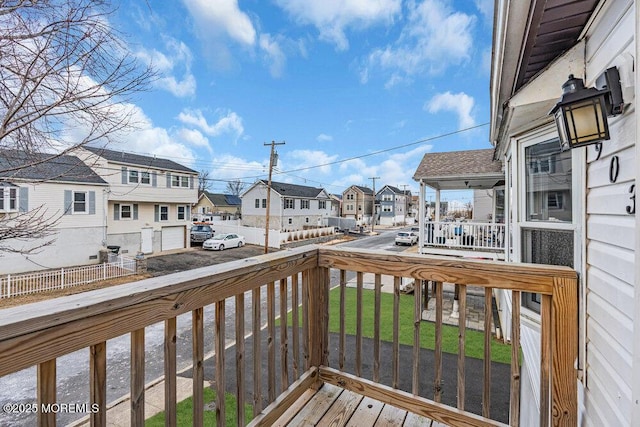 deck with a residential view, fence, and a yard