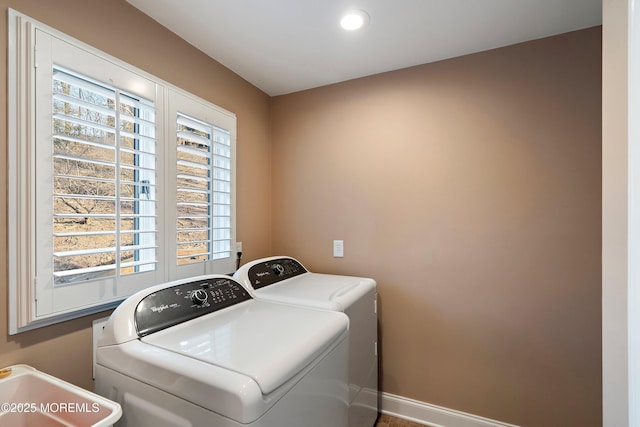 laundry room with laundry area, washing machine and dryer, and baseboards