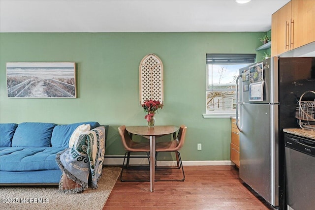 kitchen featuring stainless steel appliances, wood finished floors, and baseboards