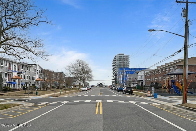 view of street featuring street lights, curbs, and sidewalks