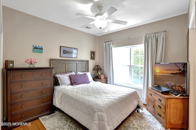 bedroom featuring visible vents, a ceiling fan, and light wood-style floors