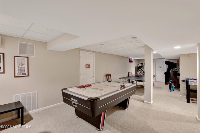 game room with light carpet, visible vents, and a drop ceiling