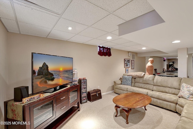 living room featuring baseboards, a drop ceiling, carpet, and recessed lighting