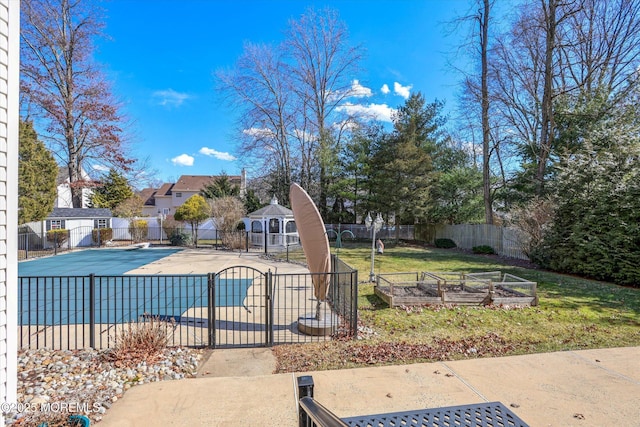 view of swimming pool featuring a yard, a patio, fence private yard, a garden, and an outdoor structure