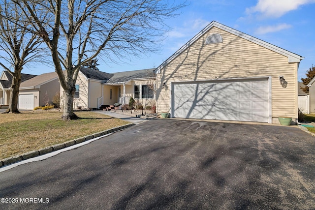 single story home featuring driveway, an attached garage, and a front yard