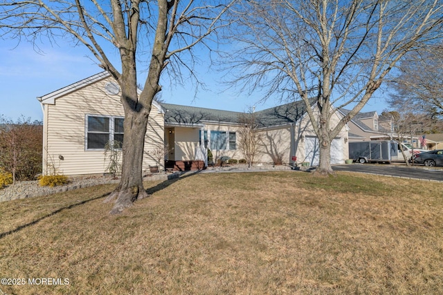 ranch-style house featuring a garage, driveway, and a front yard