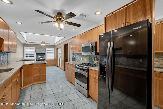 kitchen with a peninsula, visible vents, stainless steel appliances, and decorative backsplash