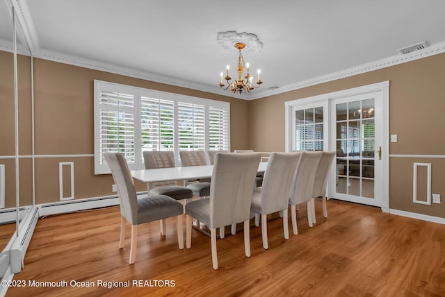 dining space with crown molding, visible vents, a notable chandelier, and wood finished floors