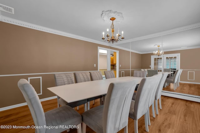 dining room featuring a chandelier, light wood finished floors, visible vents, and crown molding