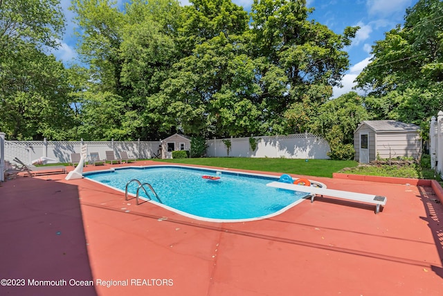 view of swimming pool featuring a fenced in pool, a fenced backyard, a yard, and a shed