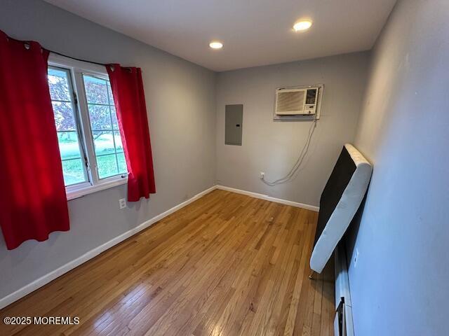 32 Cooper Ave, West Long Branch, NJ 07764 - unfurnished room featuring electric panel, a wall mounted AC, baseboards, light wood-style floors, and recessed lighting