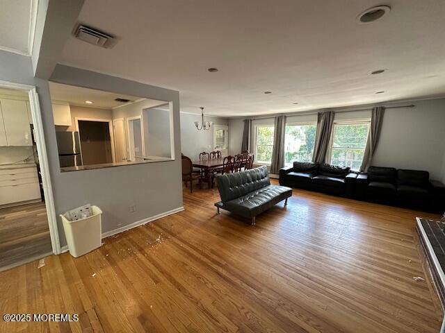 32 Cooper Ave, West Long Branch, NJ 07764 - living area with visible vents, baseboards, wood finished floors, and a chandelier