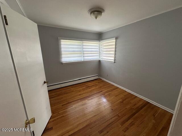 32 Cooper Ave, West Long Branch, NJ 07764 - empty room featuring wood finished floors, baseboards, and a baseboard heating unit