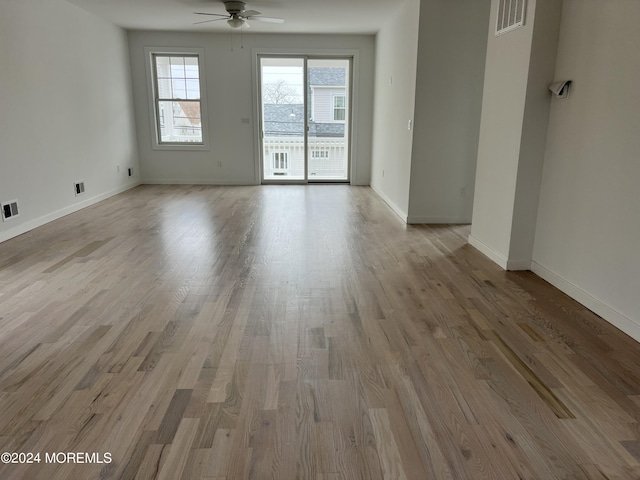 empty room featuring baseboards, wood finished floors, visible vents, and ceiling fan