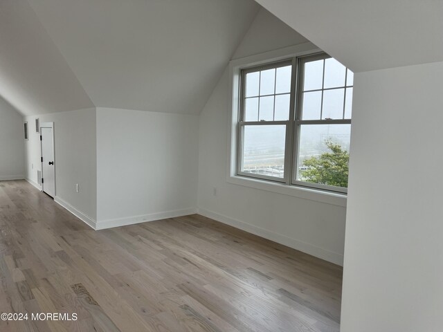 bonus room featuring baseboards, lofted ceiling, and wood finished floors