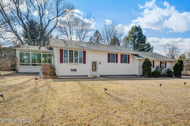 view of front of home featuring a front lawn, a chimney, and a sunroom