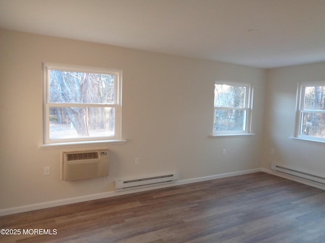 unfurnished room with a baseboard radiator, a wall mounted AC, baseboards, and wood finished floors