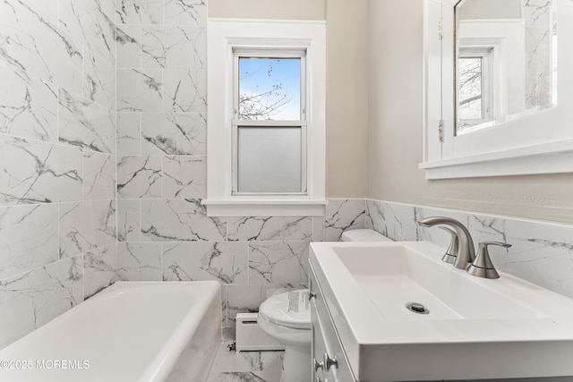 bathroom featuring toilet, marble finish floor, a bathing tub, and a wealth of natural light