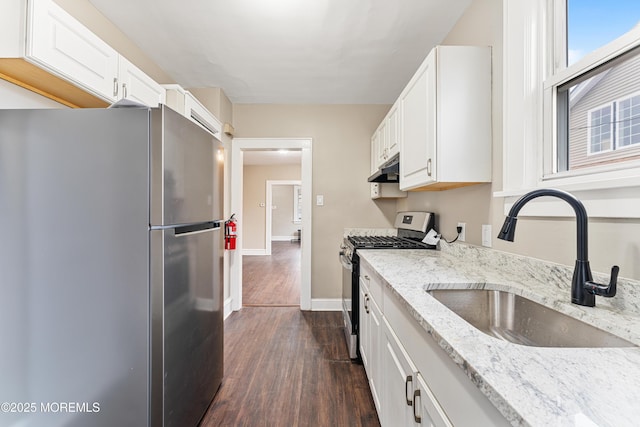 kitchen featuring appliances with stainless steel finishes, a sink, white cabinetry, and under cabinet range hood