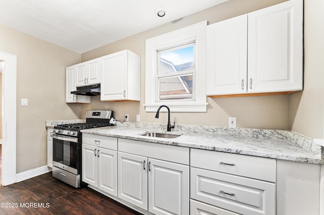 kitchen with stainless steel gas stove, a sink, under cabinet range hood, and white cabinetry