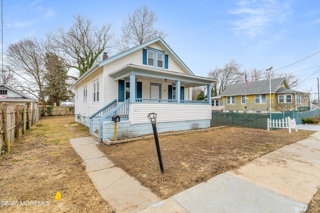 view of front facade featuring a porch, a chimney, and fence private yard