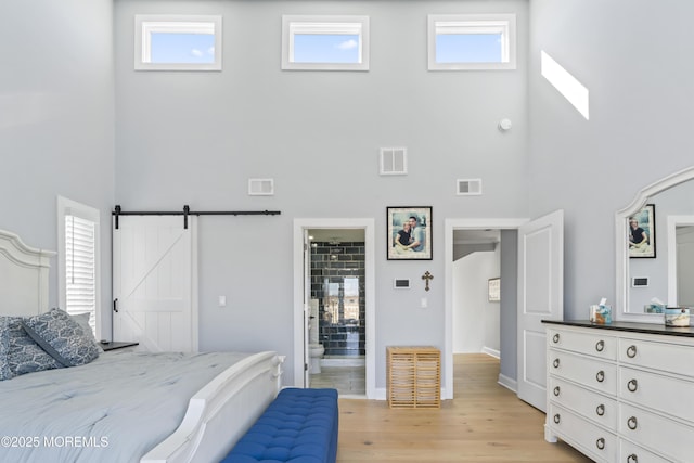 45 Royal Dr, Brick, NJ 08723 - bedroom with a high ceiling, light wood finished floors, multiple windows, a barn door, and connected bathroom