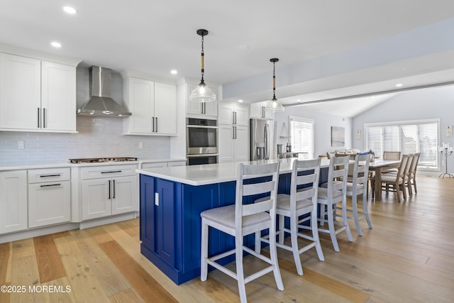 45 Royal Dr, Brick, NJ 08723 - kitchen with wall chimney range hood, stainless steel appliances, a kitchen island, decorative backsplash, and a breakfast bar area