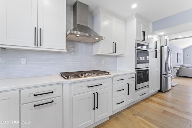 45 Royal Dr, Brick, NJ 08723 - kitchen with wall chimney exhaust hood, appliances with stainless steel finishes, white cabinets, light wood finished floors, and decorative backsplash
