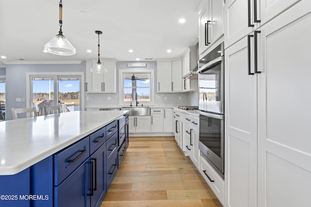 45 Royal Dr, Brick, NJ 08723 - kitchen featuring blue cabinetry, white cabinets, light countertops, backsplash, and ornamental molding