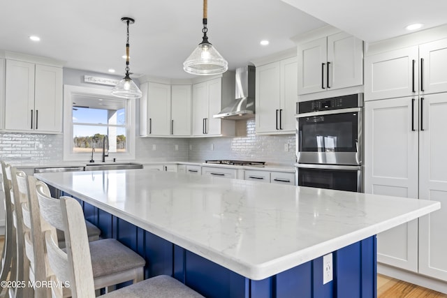 45 Royal Dr, Brick, NJ 08723 - kitchen featuring wall chimney range hood, stainless steel double oven, a breakfast bar, white cabinets, and backsplash