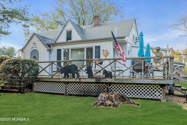 back of house with a yard, a shingled roof, and a chimney