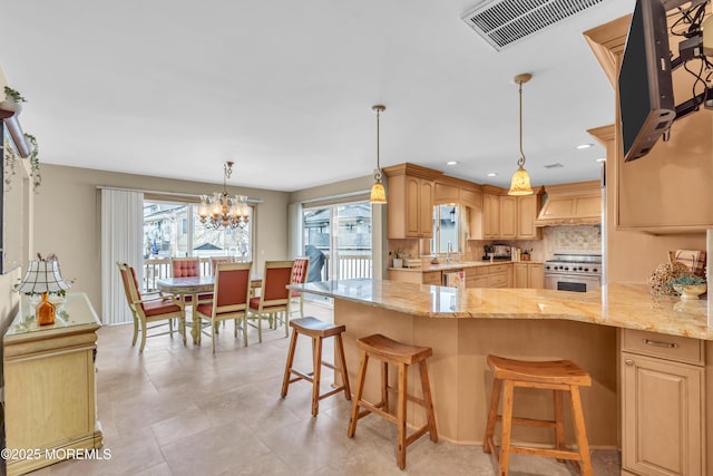 kitchen featuring light stone counters, visible vents, high end stainless steel range oven, and backsplash