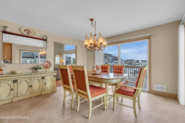 dining space with a healthy amount of sunlight, baseboards, visible vents, and a notable chandelier