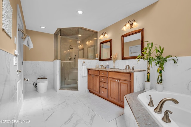 bathroom with toilet, tile walls, marble finish floor, double vanity, and a stall shower