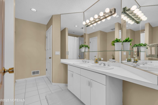 bathroom with tile patterned flooring, visible vents, a sink, and double vanity