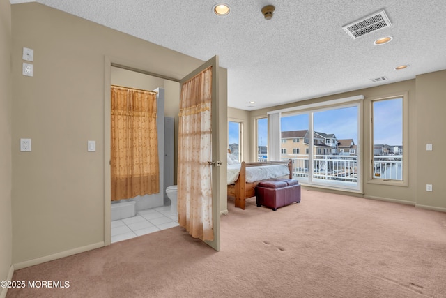 unfurnished bedroom featuring a textured ceiling, visible vents, and carpet flooring