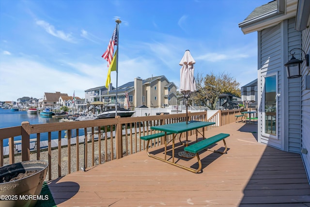 wooden terrace with a water view and a residential view