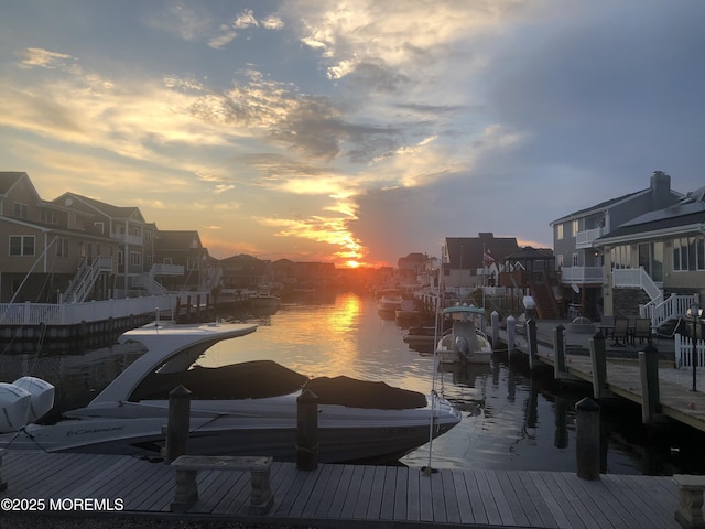 view of dock with a residential view and a water view