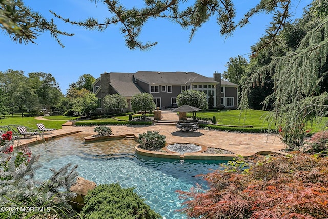 back of property featuring a patio area, a chimney, and a lawn