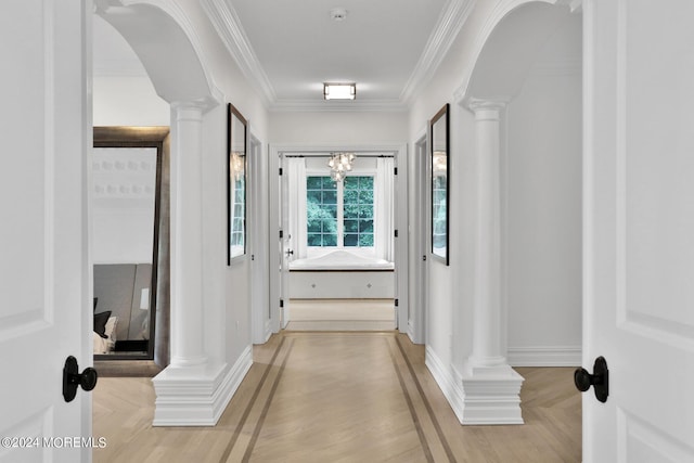 hall with light wood-style floors, decorative columns, arched walkways, and crown molding