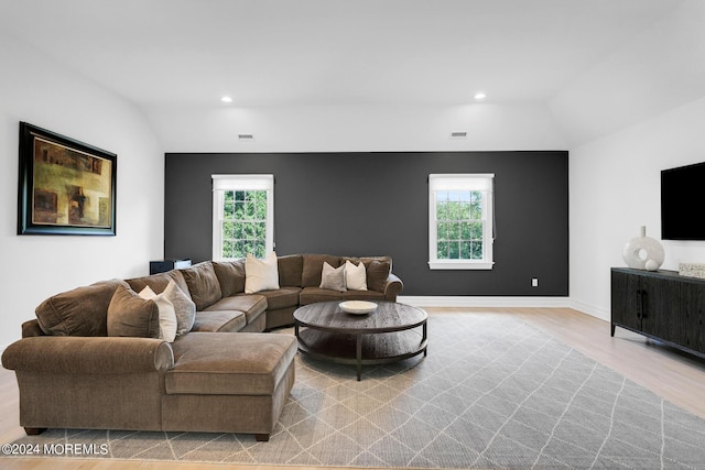 living room featuring light wood finished floors, plenty of natural light, vaulted ceiling, and recessed lighting