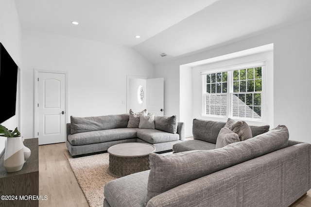 living area with vaulted ceiling, light wood-style flooring, and recessed lighting