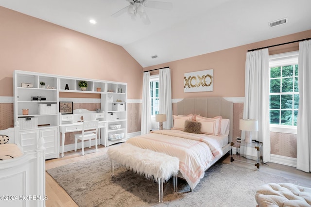 bedroom featuring lofted ceiling, visible vents, wood finished floors, and a ceiling fan